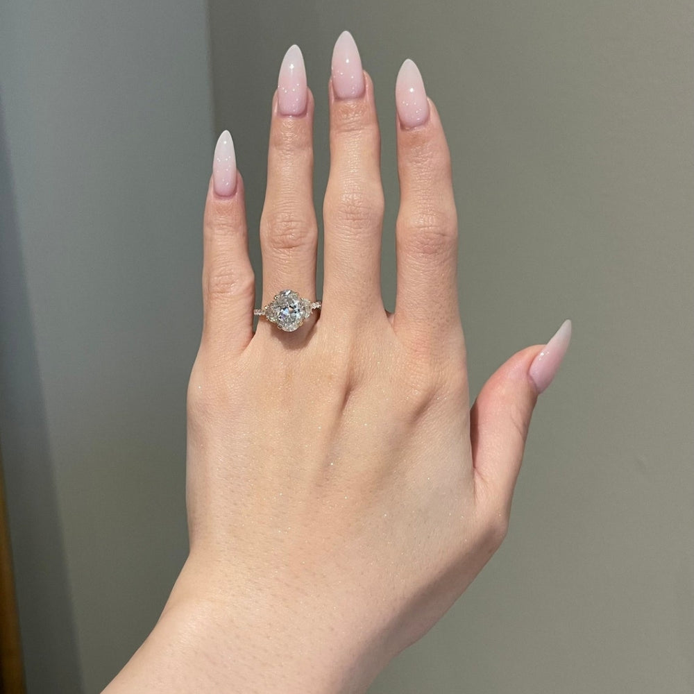 Oval diamond ring with half moon side stones