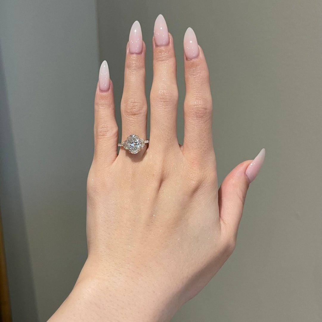 Oval diamond ring with half moon side stones