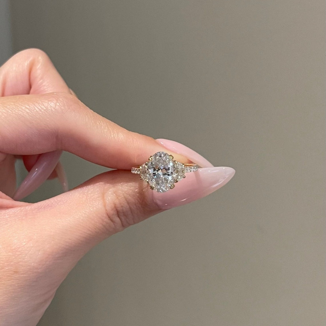 Oval center stone with half moon side stones