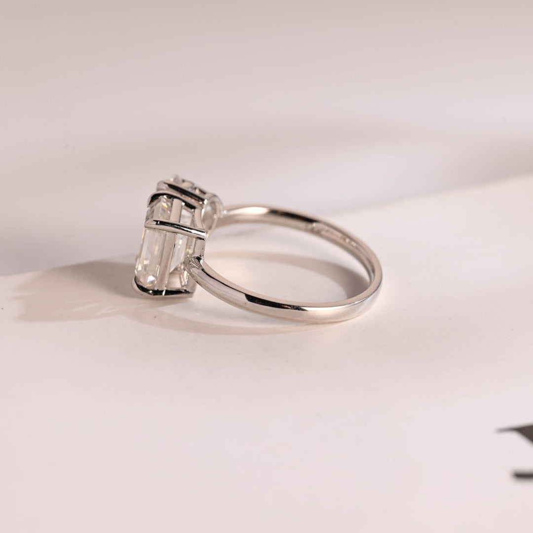 Pear cut emerald side stone ring