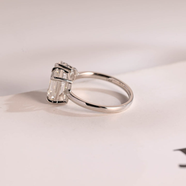 Pear cut emerald side stone ring