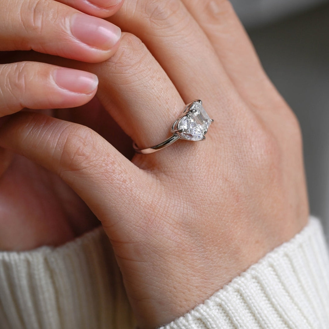 White gold pear emerald side stone ring