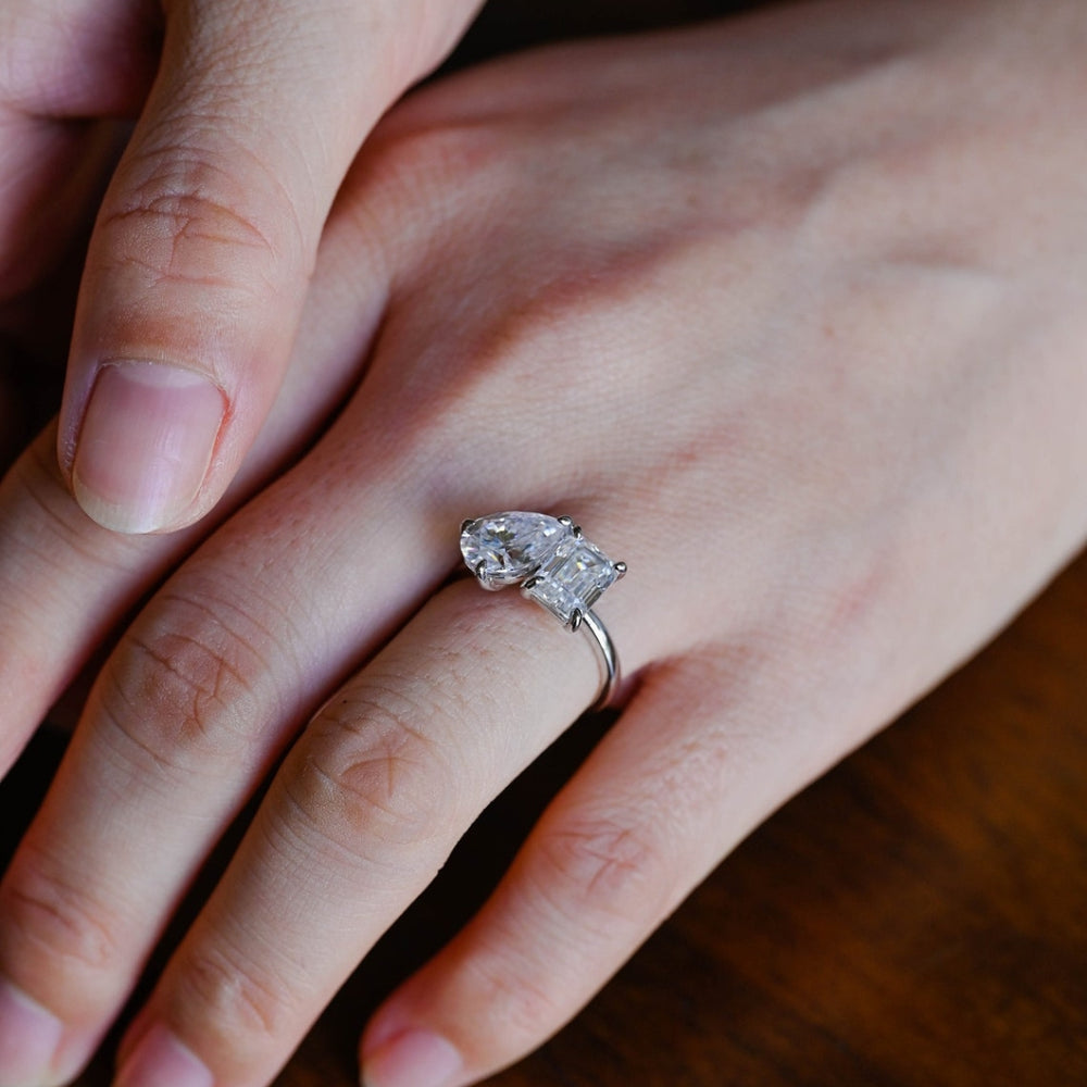 Silver pear stone with emerald side stone ring