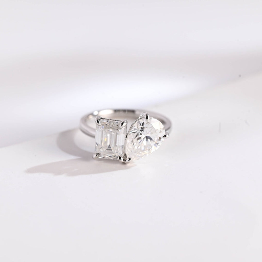 Pear shaped diamond ring with emerald side stones