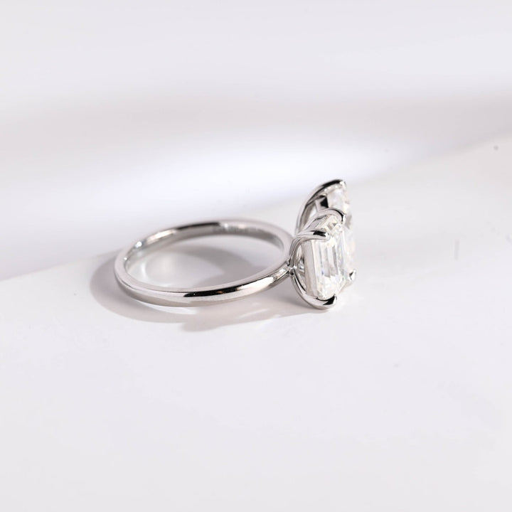 Pear cut engagement ring with emerald accents