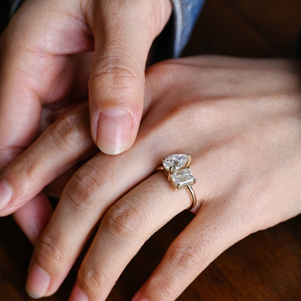 Pear cut engagement ring with emerald accents