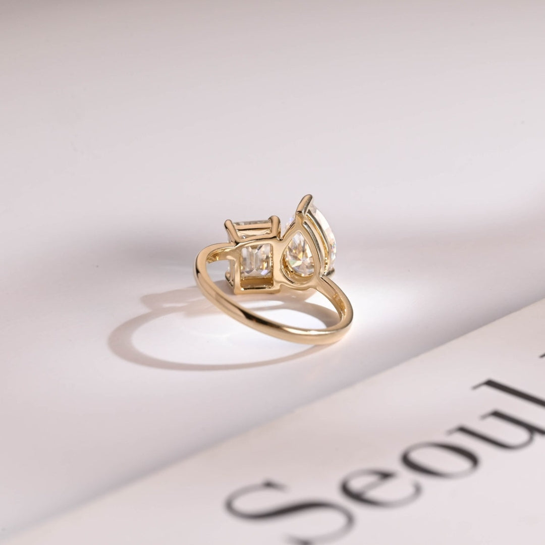 Pear solitaire ring with emerald side stones