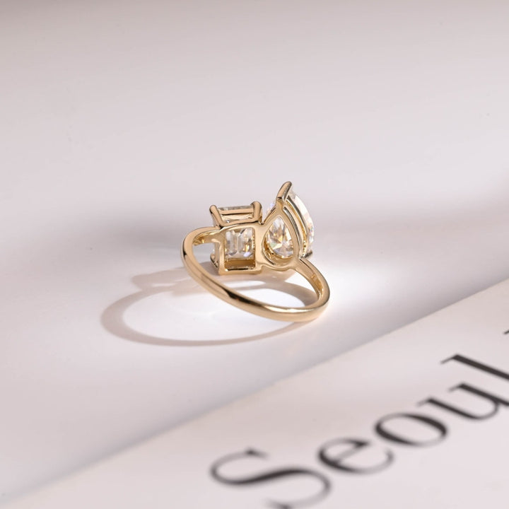 Pear solitaire ring with emerald side stones