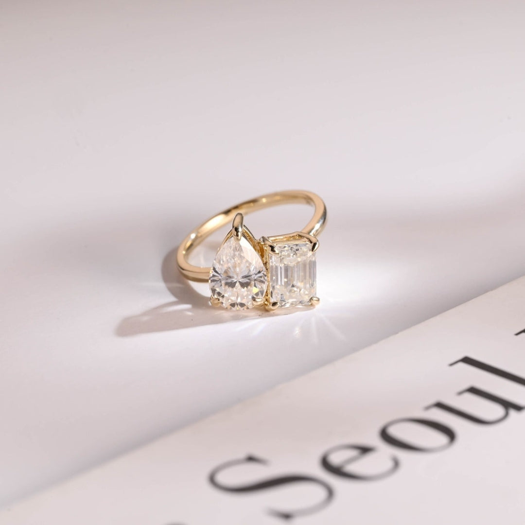 Pear shaped diamond ring with emerald side stones