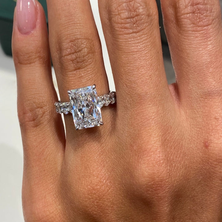 Radiant cut engagement ring with round side diamonds