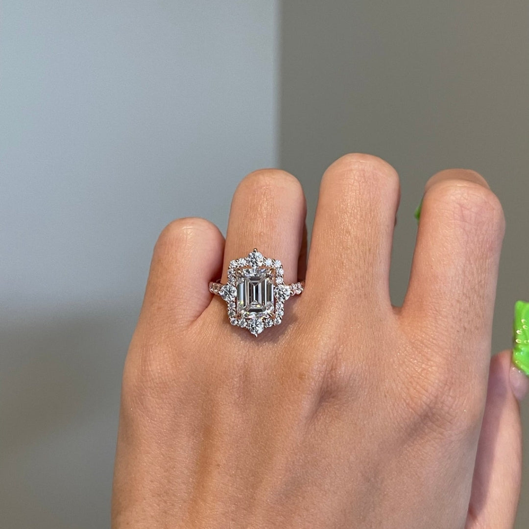 Emerald halo ring with round side stones